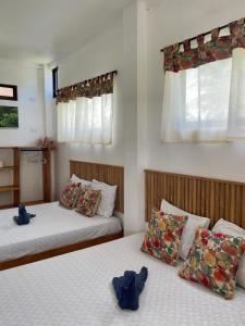 two beds sitting next to each other in a bedroom at Hotel Pura Natura Beachfront Tortuguero in Tortuguero