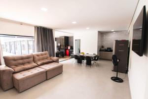 a living room with a couch and a dining room at Casa grande alto padrão á 100 metros do mar in Guaratuba