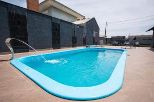 a blue swimming pool with a water fountain at Casa grande alto padrão á 100 metros do mar in Guaratuba