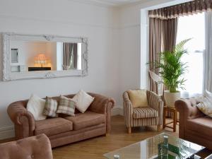 a living room with a couch and a mirror at Sandfield The Promenade in Southport