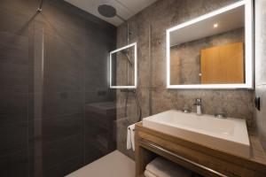 a bathroom with a sink and a shower and a mirror at Jochum Hotel Garni in Fiss