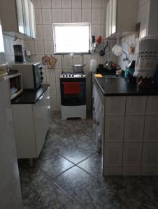 a kitchen with a sink and a stove top oven at Lar da Lilika Temporada in Cabo Frio