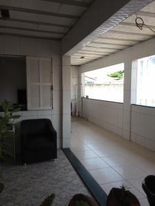 an empty room with a window and a chair at Lar da Lilika Temporada in Cabo Frio