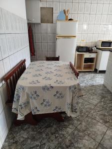 a kitchen with a table and a refrigerator at Lar da Lilika Temporada in Cabo Frio