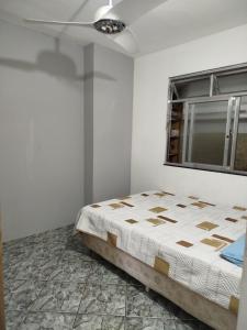 a bedroom with a bed and a window at Lar da Lilika Temporada in Cabo Frio