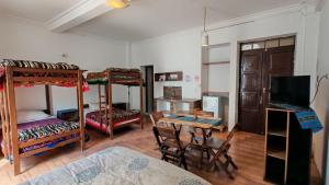 a room with four bunk beds and a table and a desk at Hostal Distrito in Sucre