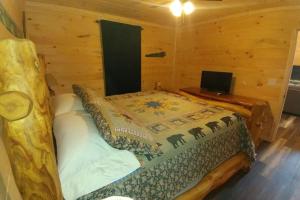 a bedroom with a bed in a log cabin at Country Bumpkin Cabin in Banner Elk