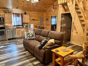 a living room with a brown couch in a cabin at Country Bumpkin Cabin in Banner Elk