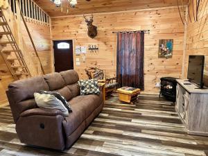 a living room with a brown couch in a cabin at Country Bumpkin Cabin in Banner Elk