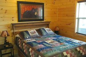 a bedroom with a bed with a picture of a horse on the wall at Little Bear Cabin in Banner Elk