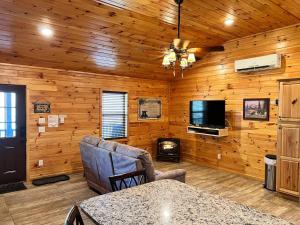 a living room with wooden walls and a tv and a fireplace at Little Bear Cabin in Banner Elk