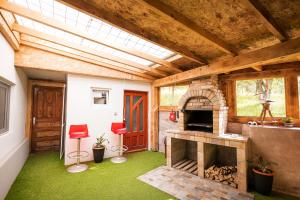 a living room with a stone fireplace and red stools at Casa Dracea in Comarnic