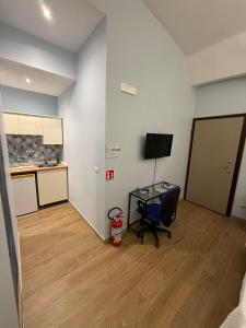 a room with a desk and a chair and a kitchen at Arthouse in Molfetta