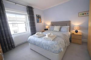 a bedroom with a bed with two towels on it at Dog Friendly Lakeland Apartment - Private Parking - Central Location in Cockermouth