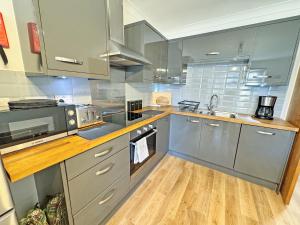 a kitchen with stainless steel appliances and wooden floors at The Annexe in Peacehaven