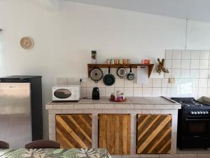 a kitchen with a counter top with a microwave at Le KAHAIA Rangiroa Tiputa in Rangiroa