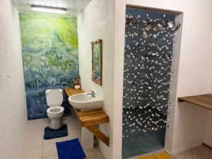 a bathroom with a sink and a toilet and a painting at Le KAHAIA Rangiroa Tiputa in Rangiroa +40 photos