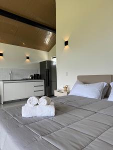 a bedroom with a large bed with towels on it at Hospedagem na natureza in Garopaba