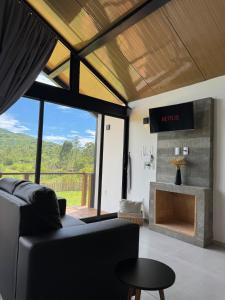 a living room with a couch and a fireplace at Hospedagem na natureza in Garopaba