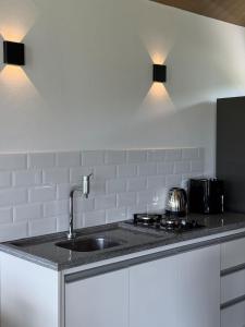 a kitchen with a sink and a stove at Hospedagem na natureza in Garopaba +15 photos