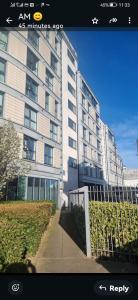 a large building with a fence in front of it at Central spacious and secure with a double bed in Colindale