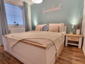 a bedroom with a large bed with a sign on the wall at Hafenidyll 46 - exklusiv am Yachthafen mit zwei Bädern - traumhafte Sonnenuntergänge inklusive in Karlshagen