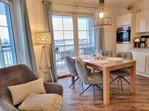 a kitchen and dining room with a table and chairs at Hafenidyll 46 - exklusiv am Yachthafen mit zwei Bädern - traumhafte Sonnenuntergänge inklusive in Karlshagen