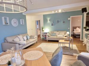 a living room with blue walls and couches at Hafenidyll 46 - exklusiv am Yachthafen mit zwei Bädern - traumhafte Sonnenuntergänge inklusive in Karlshagen