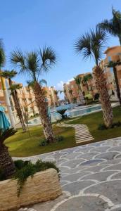 a group of palm trees in a park with buildings at La douce in Sousse +1 photo