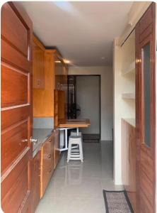 a kitchen with wooden cabinets and a stool in it at Studio Apartment in Mactan,Cebu Room203 in Lapu Lapu City +9 photos