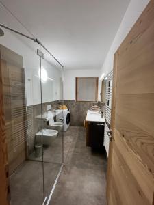 a bathroom with two toilets and a glass shower at Baita Piazza in Valdisotto +9 photos