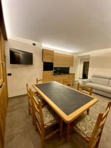 a living room with a table and chairs and a couch at Baita Piazza in Valdisotto