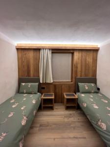 a room with two beds and a window at Baita Piazza in Valdisotto