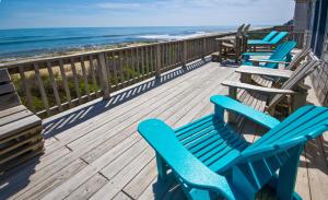 a row of blue chairs on a deck overlooking the ocean at Breakaway - Duck, Sanderling, Oceanfront, Ocean View, Pets OK, Community Pool in Duck