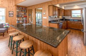 a kitchen with a large counter with stools in it at Breakaway - Duck, Sanderling, Oceanfront, Ocean View, Pets OK, Community Pool in Duck