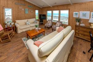 a living room with a couch and a table at Breakaway - Duck, Sanderling, Oceanfront, Ocean View, Pets OK, Community Pool in Duck
