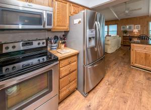 a kitchen with stainless steel appliances and wooden cabinets at Breakaway - Duck, Sanderling, Oceanfront, Ocean View, Pets OK, Community Pool in Duck