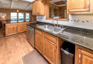 a kitchen with wooden cabinets and a stainless steel sink at Breakaway - Duck, Sanderling, Oceanfront, Ocean View, Pets OK, Community Pool in Duck +31 photos