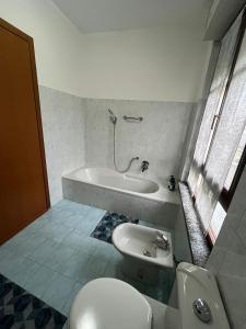 a bathroom with a toilet and a tub and a sink at AlbaChiara Apartment in Gallarate +19 photos