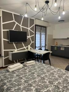 a dining room with a table and a tv on a wall at AlbaChiara Apartment in Gallarate