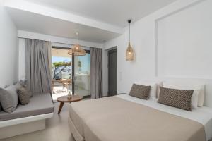 a white bedroom with a bed and a couch at Etherio Suites Milos in Pollonia +80 photos
