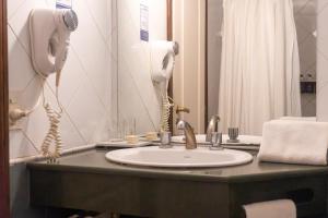 a bathroom counter with a sink and a phone at Patagonia Sur Hotel in San Carlos de Bariloche +16 photos