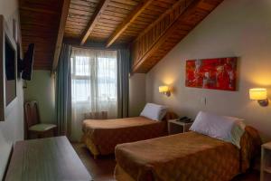 a hotel room with two beds and a window at Patagonia Sur Hotel in San Carlos de Bariloche