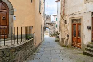 an alley in an old town with an archway at The Townhouse Barga in Barga