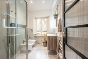 a bathroom with a glass shower and a toilet at The Townhouse Barga in Barga +17 photos