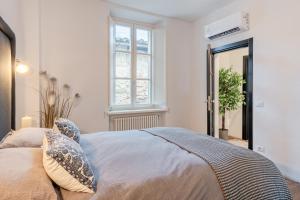 a bedroom with a bed with pillows and a window at The Townhouse Barga in Barga