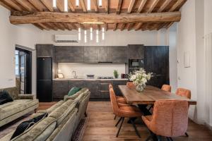 a kitchen and dining room with a wooden table and chairs at The Townhouse Barga in Barga