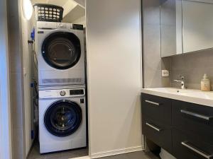 a washer and dryer in a bathroom with a sink at Sørlandet, nær stranden og Kristiansand dyrepark in Søgne