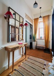 a living room with a wooden table and a mirror at Luxury OldTown Free Parking in Vilnius