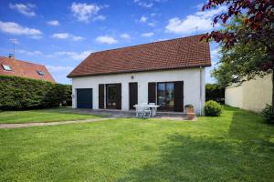 a small white house with a table in the yard at Maison individuelle, 100m2, 3 chambres, jardin clos in Fort-Mahon-Plage